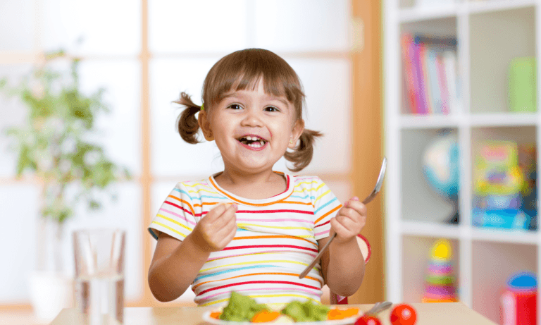Happy toddler enjoys healthy meal.