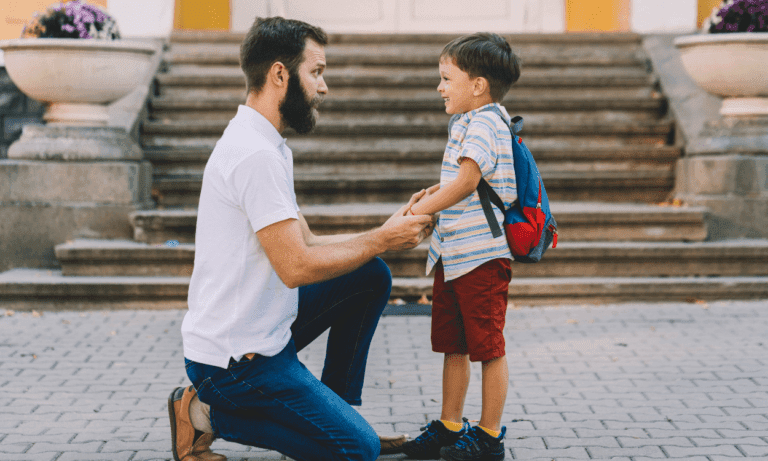 Father and son holding hands, first day of school.