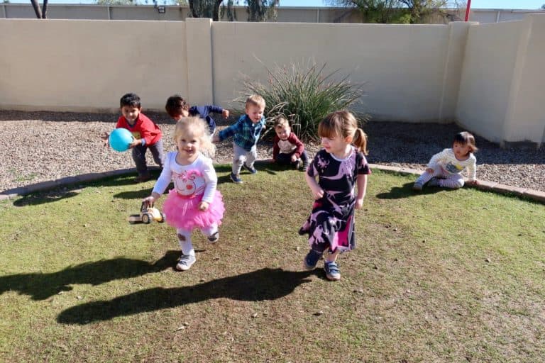 Children playing outdoors on grass.