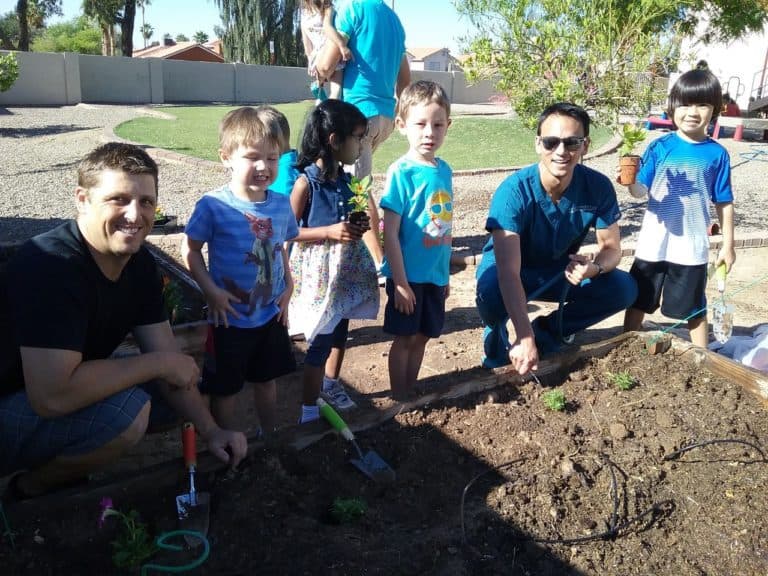 Group of children gardening with adults.
