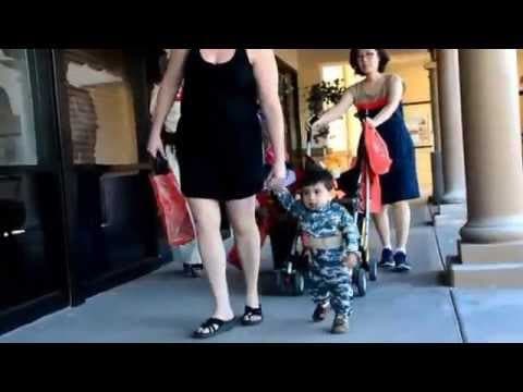 A woman and boy in costume walk with a stroller.