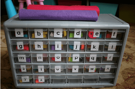Alphabet storage with felt letters in drawers.