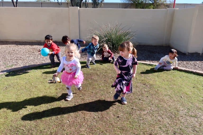 Children playing outdoors on grass.
