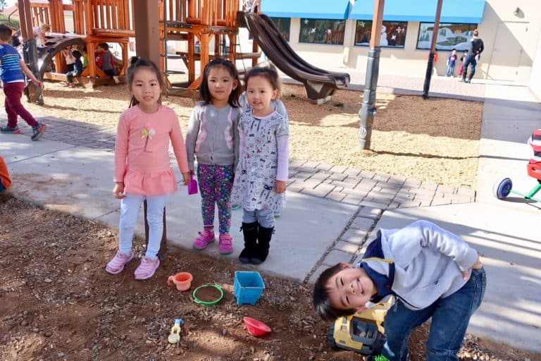 Children playing on a playground with toys.