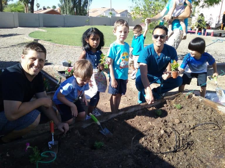 Adults and children gardening together.