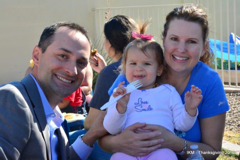 Family portrait with a little girl smiling.