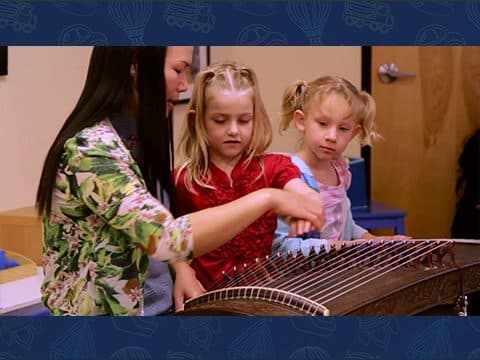 Two girls playing a Chinese zither.