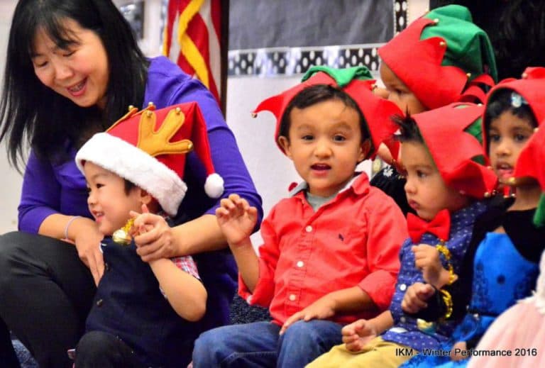 Children in Santa hats at a performance.