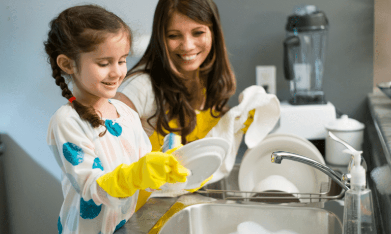 Girl and mom washing dishes together.