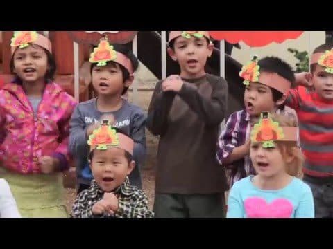 Children singing with turkey hats on.
