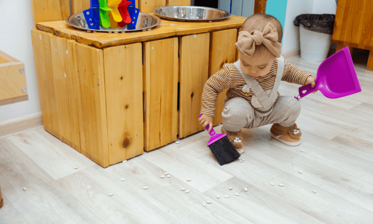 Toddler sweeping spilled beans.