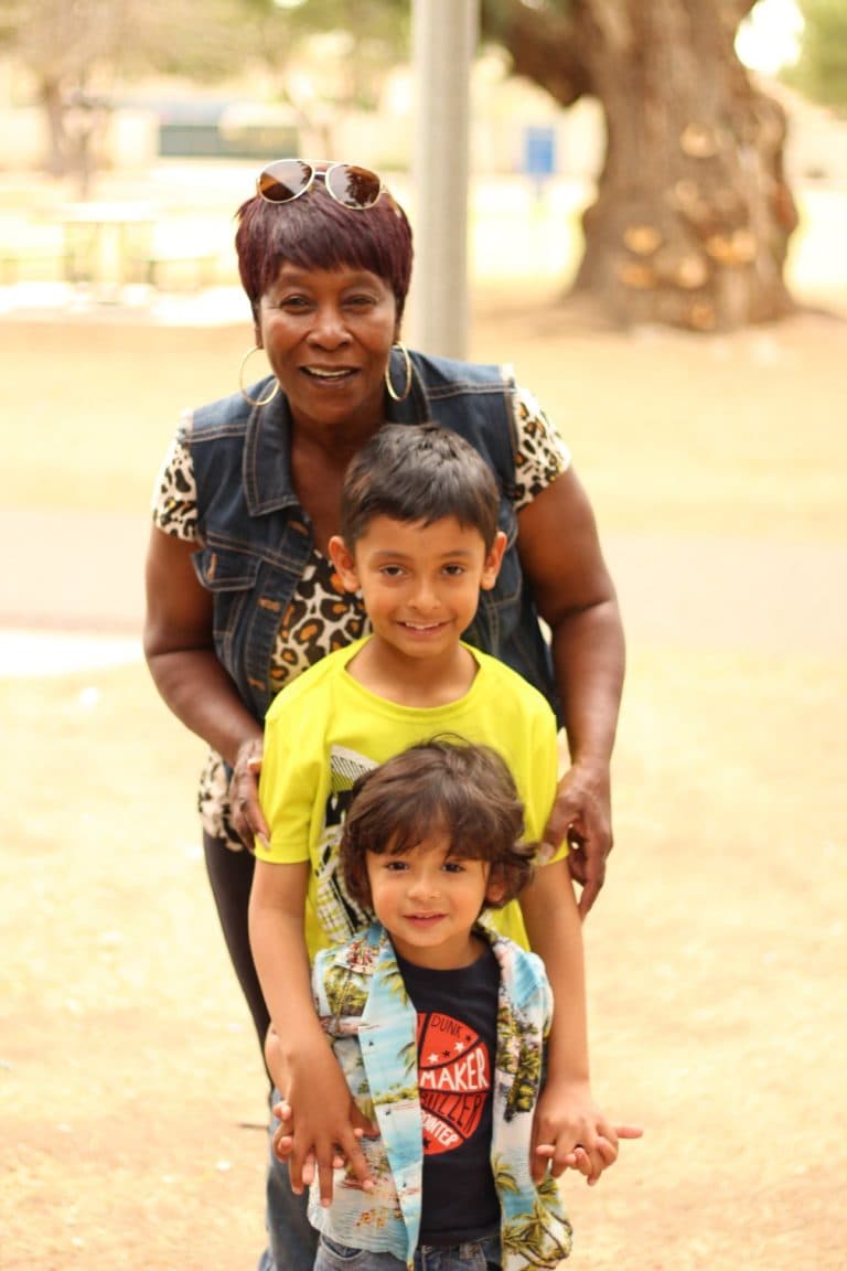 A woman and two boys smiling for a photo.