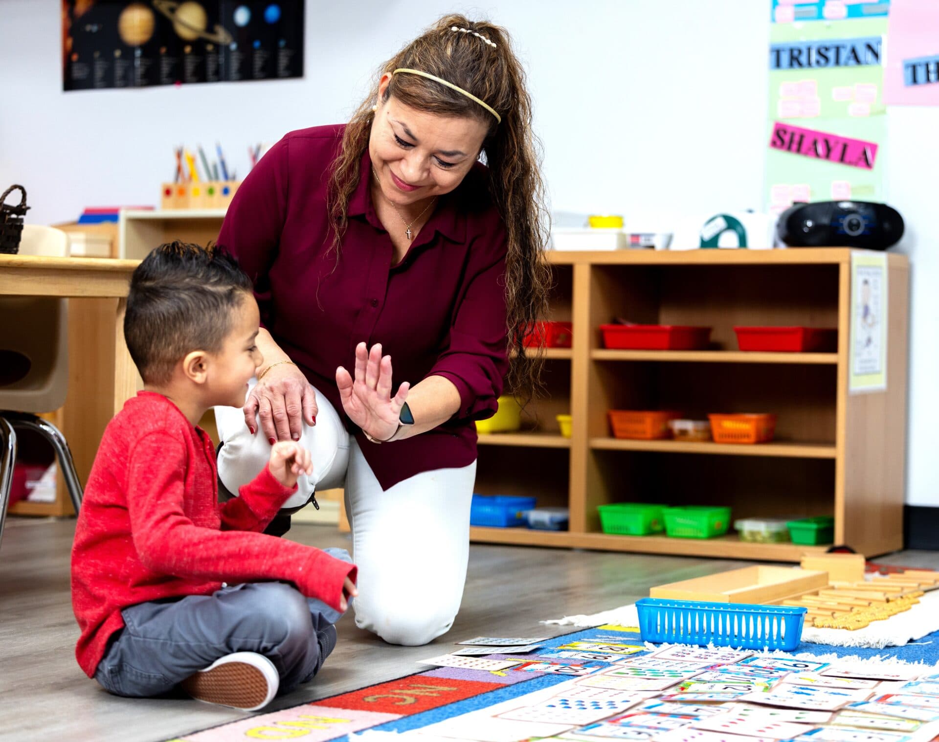 A teacher greeting a child at Inspire Kids Montessori